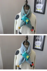 Detail of knitted children's scarves with 3D dinosaur accents and colorful plush pom-poms