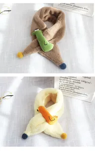 Détail d'une écharpe en peluche pour enfant avec crocodile mignon et pompon doux