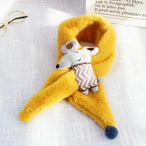 Close-up of a yellow plush kids' scarf featuring a gray mouse doll and a blue pompom