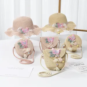 Detail von Strohhut und passender Umhängetasche mit rosa Schmetterling und Perlenakzenten