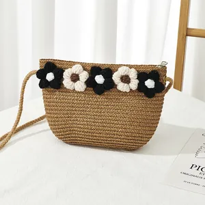 Détail du sac en paille fait main avec fleurs au crochet et fermeture éclair en métal