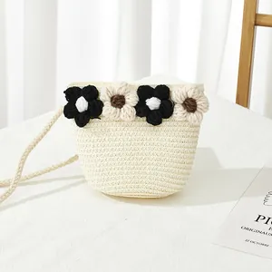 Détail d'un mini sac bandoulière en paille avec fleurs au crochet et fine bandoulière