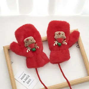 Detail of red plush mittens with hanging cord and cute cartoon reindeer holiday design