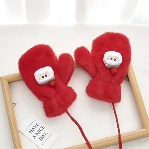 Detailed macro of red plush mittens with cartoon rabbit patch and hanging neck rope
