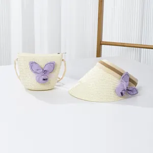 Vue détaillée du chapeau de paille et du petit sac bandoulière assorti avec nœud violet