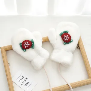 Detail of plush white mittens featuring snowflake embroidery and soft faux rabbit fur texture