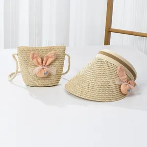 Détail du chapeau de soleil en paille et sac assorti avec oreilles de lapin et nœud