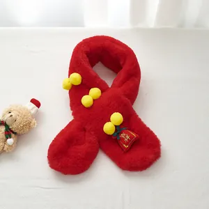 Macro view of plush red kids scarf with lucky fortune bag and soft yellow pom-poms
