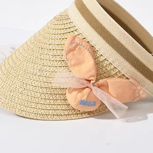 Détail d'un chapeau de paille pour filles avec nœud orange et broderie SMILE