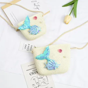 Detail of white woven straw girls bag featuring blue sequined mermaid tail and pearls