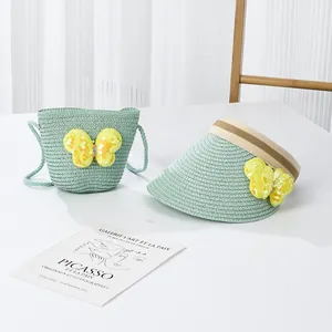 Détail d'un ensemble chapeau de paille et sac vert menthe pour enfant avec nœuds jaunes