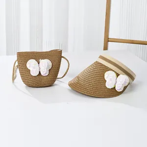 Détail de la visière en paille et du sac assorti avec des papillons à paillettes décoratifs