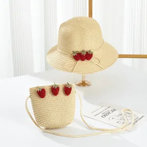 Close-up of girls' straw hat and matching crossbody bag with cute strawberry charms