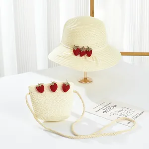 Detail of cream straw sun hat and matching crossbody bag with cute 3D strawberry accents