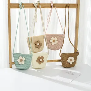 Dettaglio di mini borse a tracolla intrecciate a mano con fiori colorati in cinque tonalità