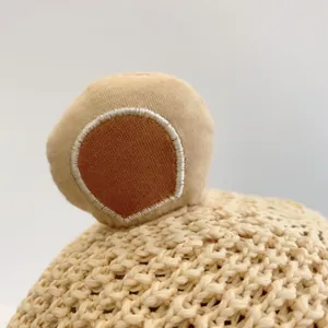 Détail de l'oreille d'ours sur un chapeau de paille tissé à la main pour bébés et enfants