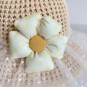 Detailed close-up of straw hat featuring a yellow polka dot 3D floral accent with lace