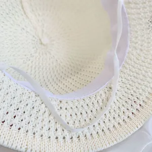 Detail van de binnenkant van een beige strohoed met fijn weefsel en elastische band