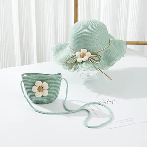 Dettaglio di cappello di paglia verde menta e borsa a tracolla con decorazioni floreali