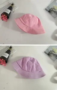 Texture detail of pink and purple corduroy sun hats for kids in a stylish flat lay