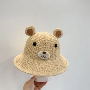 Vue détaillée du chapeau de soleil en paille beige pour enfants avec oreilles d'ours