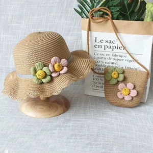 Détail du chapeau de soleil en paille pour enfant et mini sac avec fleurs bicolores