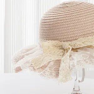 Close-up of fine weave straw hat featuring white lace trim and elegant bow detail