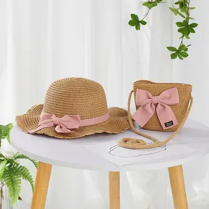 Detail of straw hat and crossbody bag with pink bow and Hand Made woven label