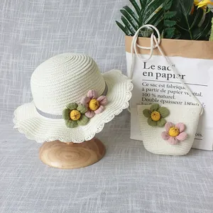 Détail de chapeau de paille et sac avec fleurs et dentelle sur fond de lin gris élégant