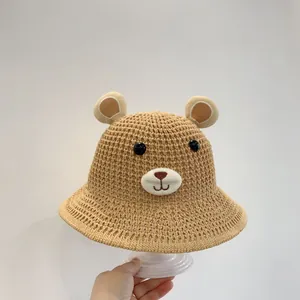 Vue détaillée d'un chapeau de soleil tressé pour enfant avec oreilles d'ours et broderie