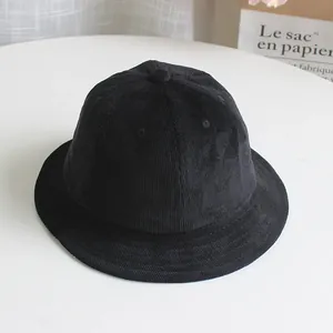 Detail view showing vertical corduroy texture and dome design of the black bucket hat