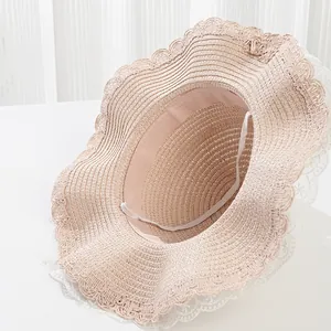Close-up of girls' straw sun hat with white lace trim and elastic windproof strap