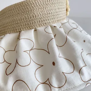 Detail of straw woven brim and floral fabric stitching on a children's sun hat