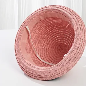 Detailed inner view of pink straw sun hat showing woven texture and elastic chin strap