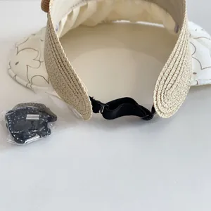 Detail of straw sun hat showing inner sweatband, floral brim, and adjustable strap