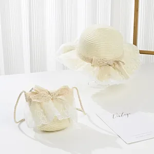 Detail of girls straw sun hat and matching lace crossbody bag in creamy white color