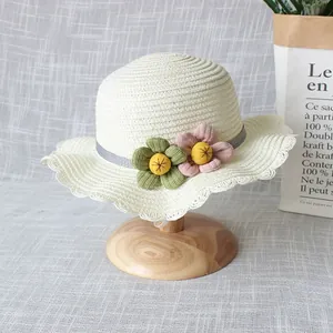 Vue détaillée du chapeau de paille crème avec broderie florale et bord ondulé