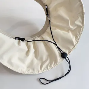 Detail of adjustable drawstring and hook on cream-white kids' foldable sun hat visor