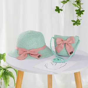 Detail of straw hat and bag set with pink bows and handmade label for girls