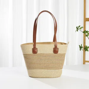 Detail van de gevlochten strandtas met gestreepte textuur en bruine handgrepen
