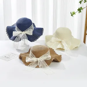 Straw sun hats with wide wavy brims and lace bows in navy blue, cream, and brown