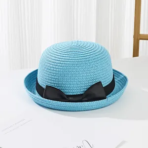 Close-up of sky blue woven straw hat with elegant black bow ribbon and fine texture