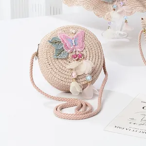 Detail of children's straw bag featuring sequin butterfly, floral embroidery and tassels