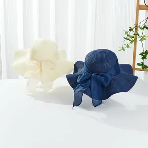 Summer wide brim sun hats with wave edges and mesh bows in cream and navy blue colors