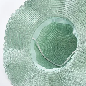 Detail view of the mint green straw hat showing woven texture and interior sweatband