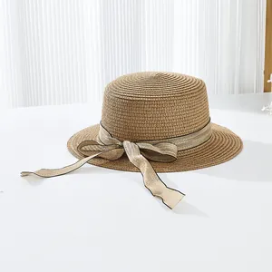 Vue détaillée de la texture en paille tressée et du ruban élégant d'un chapeau d'été plat