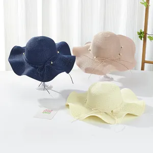 Detailed texture of wave-edge straw hats with elegant pearl and bow decorations