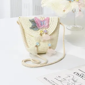 Detail of straw woven crossbody bag with pink 3D butterfly and blue leaf embroidery