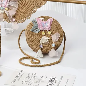 Detail of round straw purse featuring sequin butterfly embroidery and bead charms