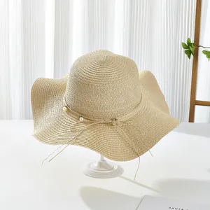 Elegant beige wide-brim straw sun hat with pearl ribbon decoration and wavy edge